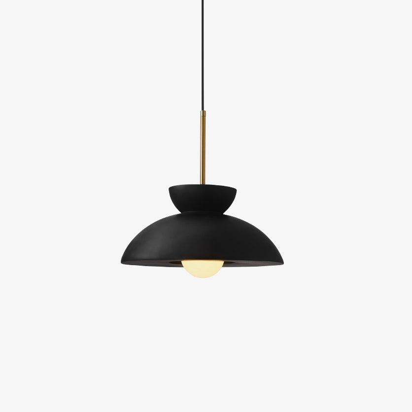 Black matte dome pendant from Clérachic with a brass stem, shown on a pale grey backdrop with the bulb just visible.