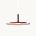 Orange Clérachic pendant light on a plain white backdrop, with a wide flat disc shade, a black stem and a round light below.