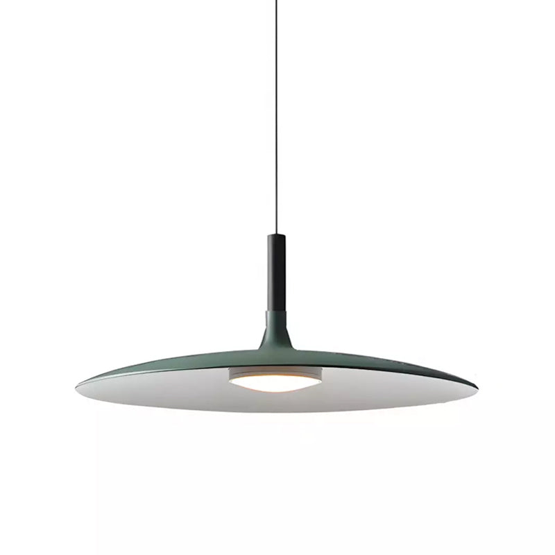 Front view of this green Clérachic disc pendant on white, with a thin cord, black stem and a soft light below.