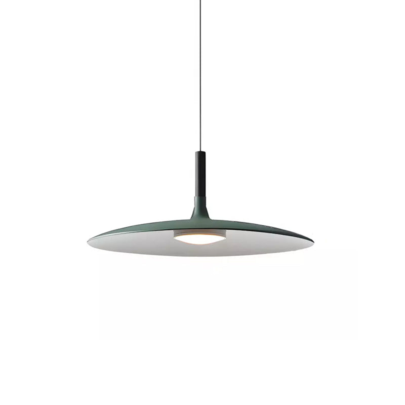Smaller green Clérachic pendant on white, its wide disc shade with a lit round diffuser and a thin black cord.