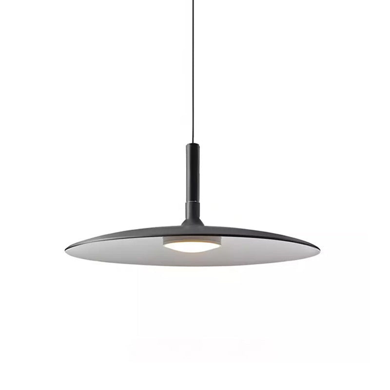 Large black Clérachic disc pendant on white, with a pale underside and a round warm light below the shade.