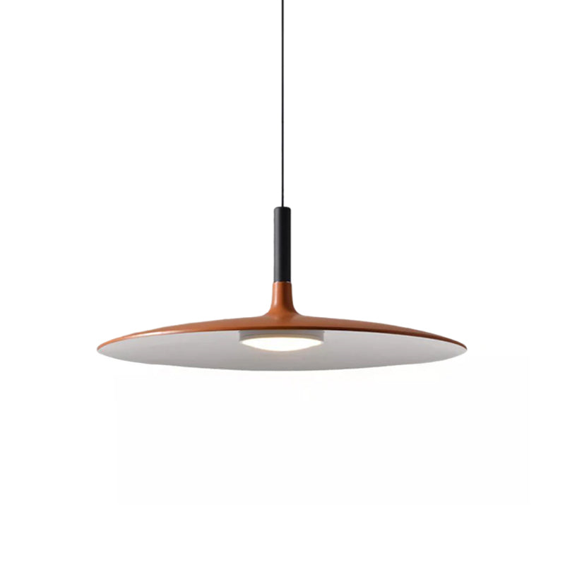 Large orange Clérachic pendant light on white, its wide disc shade with a black stem and a pale underside.