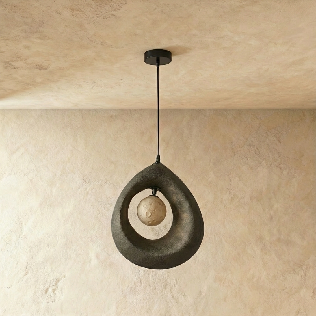 Clérachic dark grey roughcast teardrop pendant with the crater-textured globe unlit inside its open ring, on a black cord.