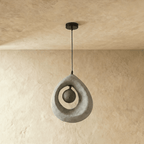 Clérachic light grey roughcast teardrop pendant with the dark crater-textured globe unlit inside its open ring.