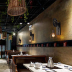 Clérachic pulley sconces lined along a restaurant wall above leather booths and set tables.