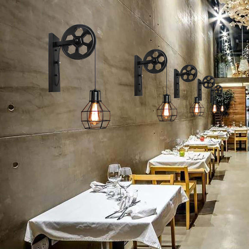 A row of Clérachic pulley sconces on a concrete wall above white-clothed restaurant tables.