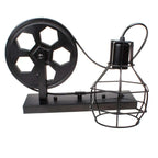 Clérachic pulley sconce in black finish on white, iron wheel feeding cord to the caged bulb.