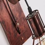 Macro of the Clérachic pulley sconce backplate in copper tones with its cage shade below.