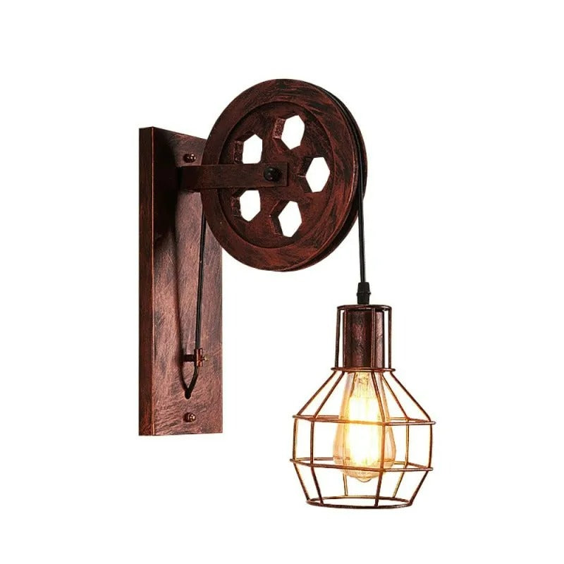 The Clérachic pulley sconce lit on white, amber filament bulb caged in dark iron.
