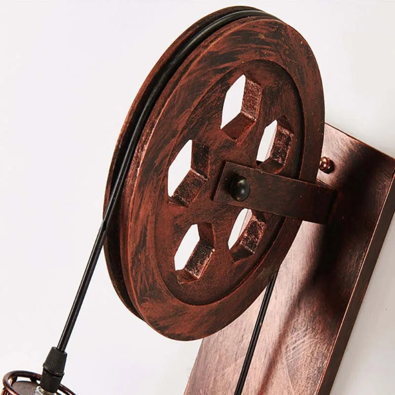 Macro of the Clérachic pulley wheel in copper, cord looping across the cast spokes.