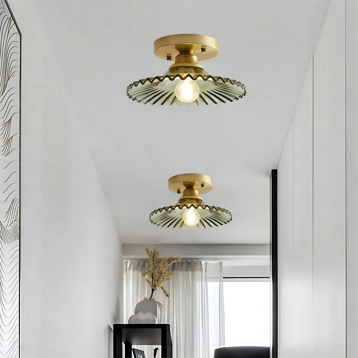 Two green ribbed Clérachic flush lights seen from below, their gold canopies set against a white ceiling above a bright hallway.