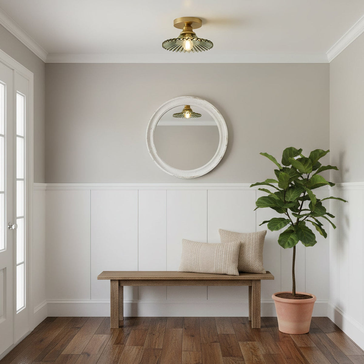 Green ribbed glass Clérachic ceiling light above an entrance hall with a round white mirror, a wooden bench and a potted fig.