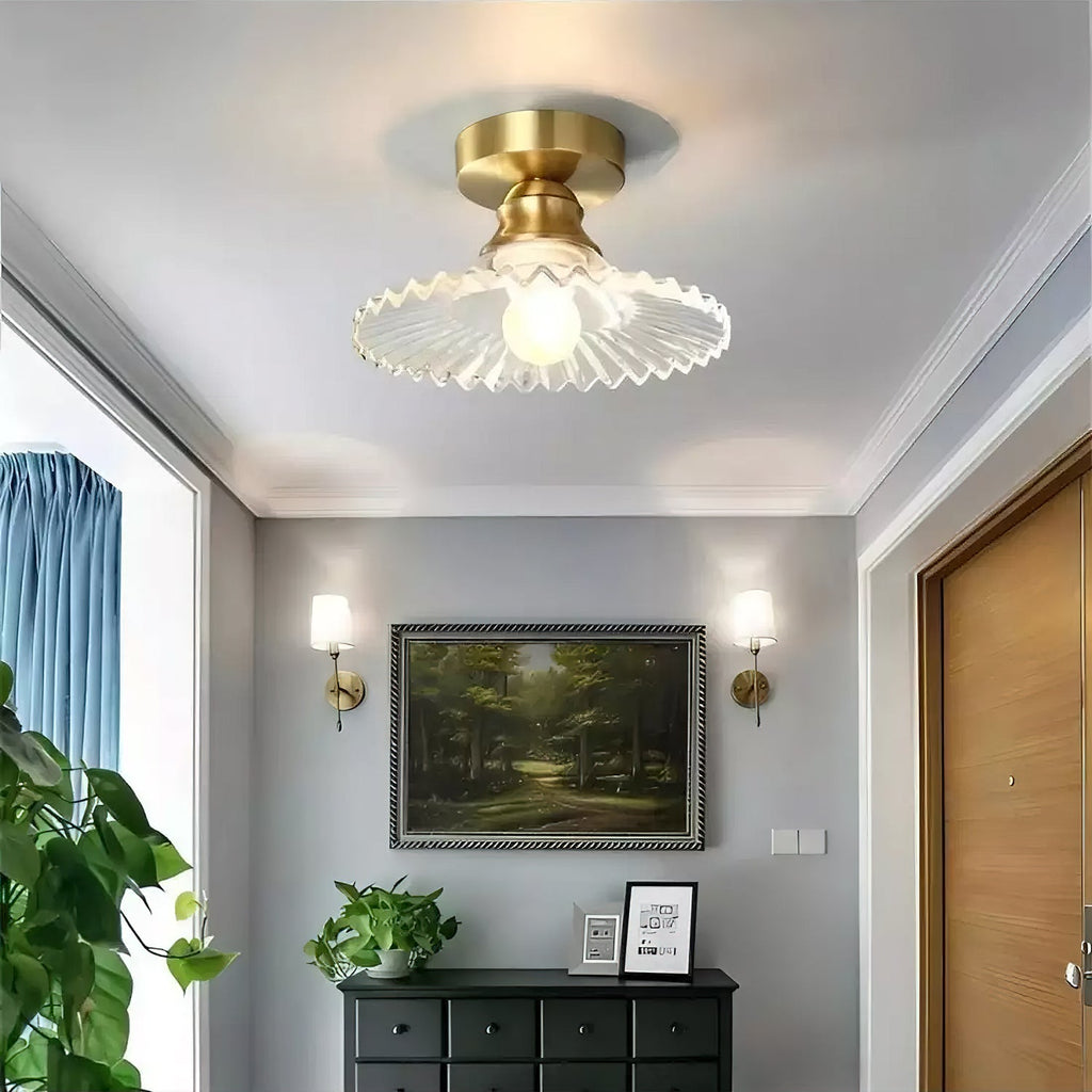 Clear ribbed glass Clérachic flush light lit above a grey hallway, with a dark chest of drawers and a landscape painting below.