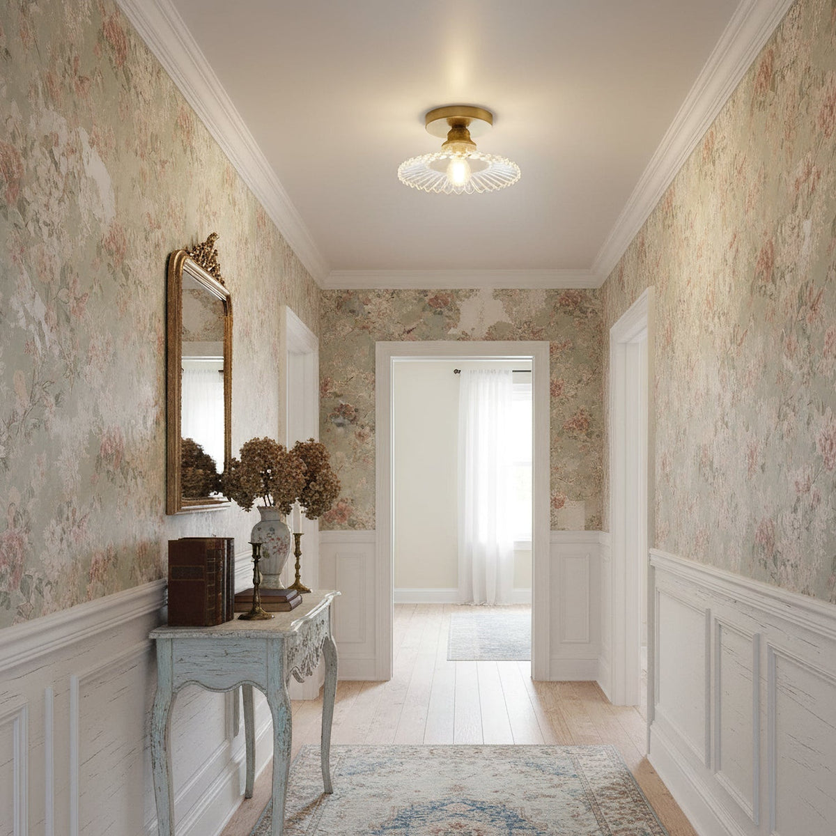 A clear glass Clérachic flush light in a hallway papered in a faded floral pattern, with a pale blue console table beneath.