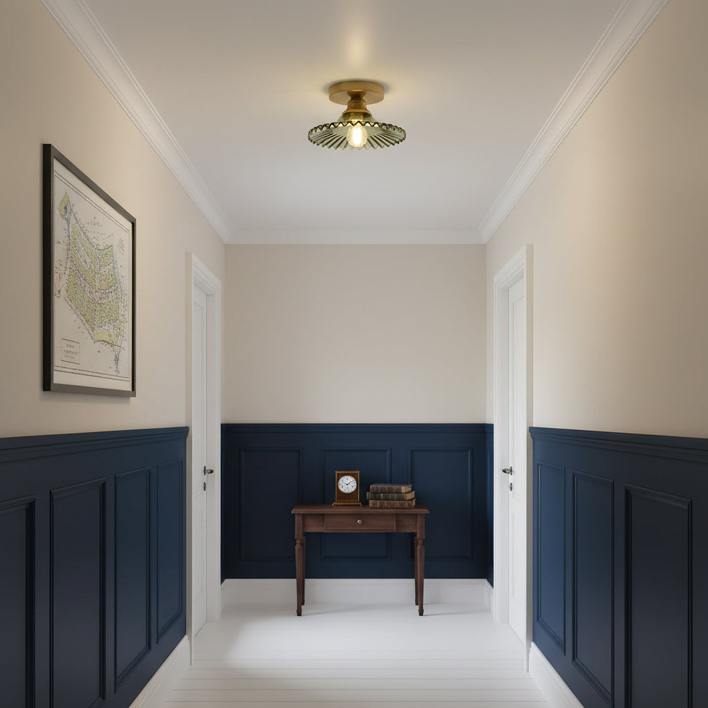 Green glass Clérachic flush light above a hallway with navy panelling, a small desk and a framed map on the wall.