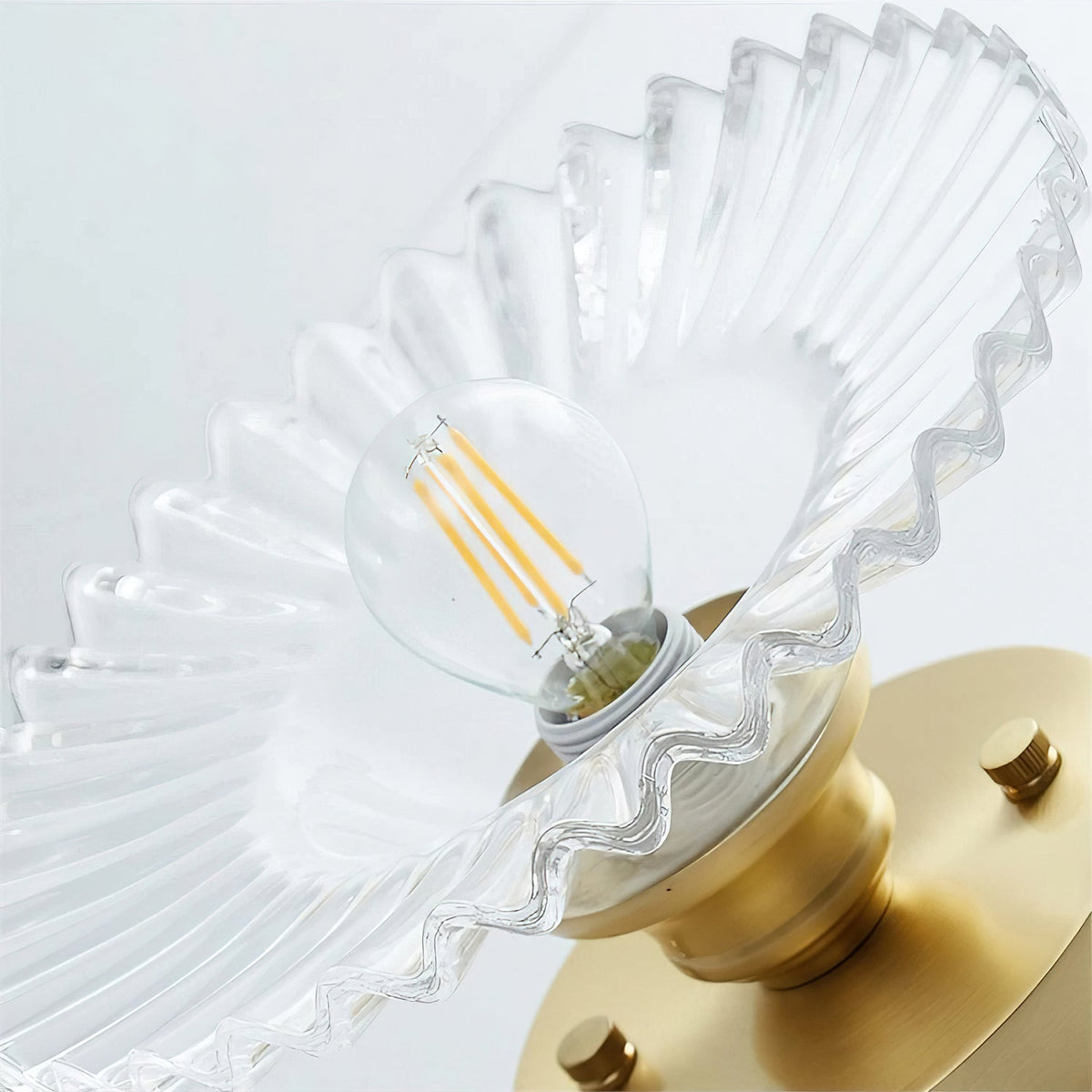 Close view up into the clear ribbed glass shade of this Clérachic ceiling light, showing the filament bulb and gold canopy.