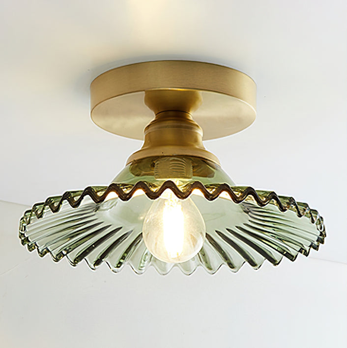 Lit Clérachic ceiling light with a green ribbed glass shade and a warm filament bulb under a gold canopy.