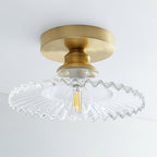 Clear ribbed glass Clérachic ceiling light with an unlit filament bulb, seen from below against a pale ceiling.