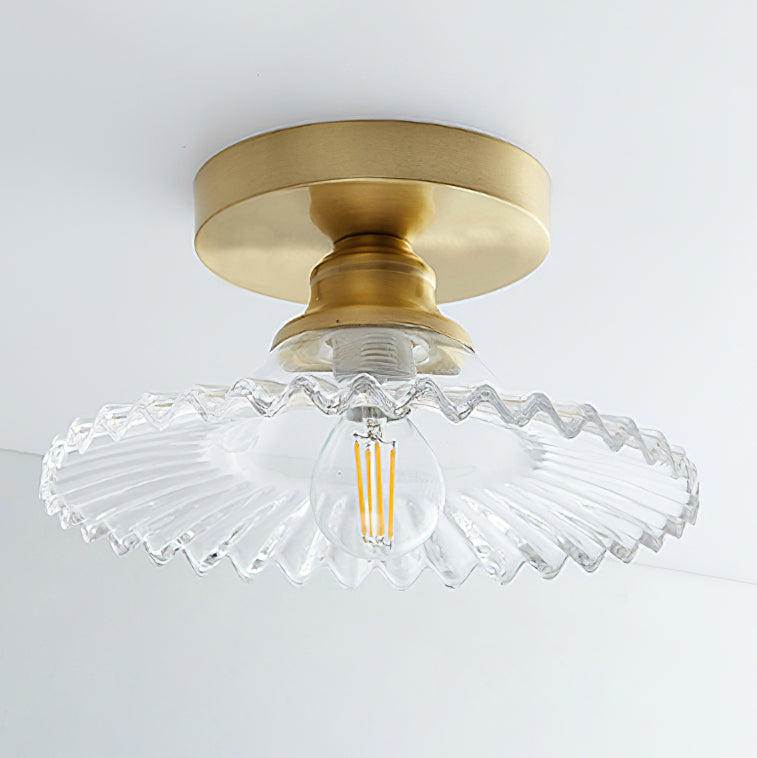 Clear ribbed glass Clérachic ceiling light with an unlit filament bulb, seen from below against a pale ceiling.