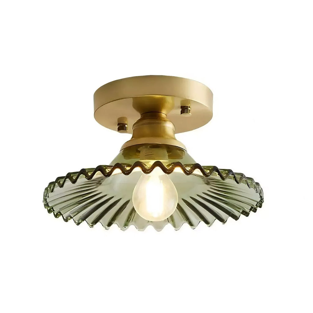 Green ribbed glass Clérachic flush light lit on a plain white backdrop, with a gold canopy and a small frosted bulb.
