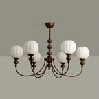Unlit six-light Clérachic chandelier showing pale ribbed glass globes and the antique bronze arms, against a grey wall and ceiling.