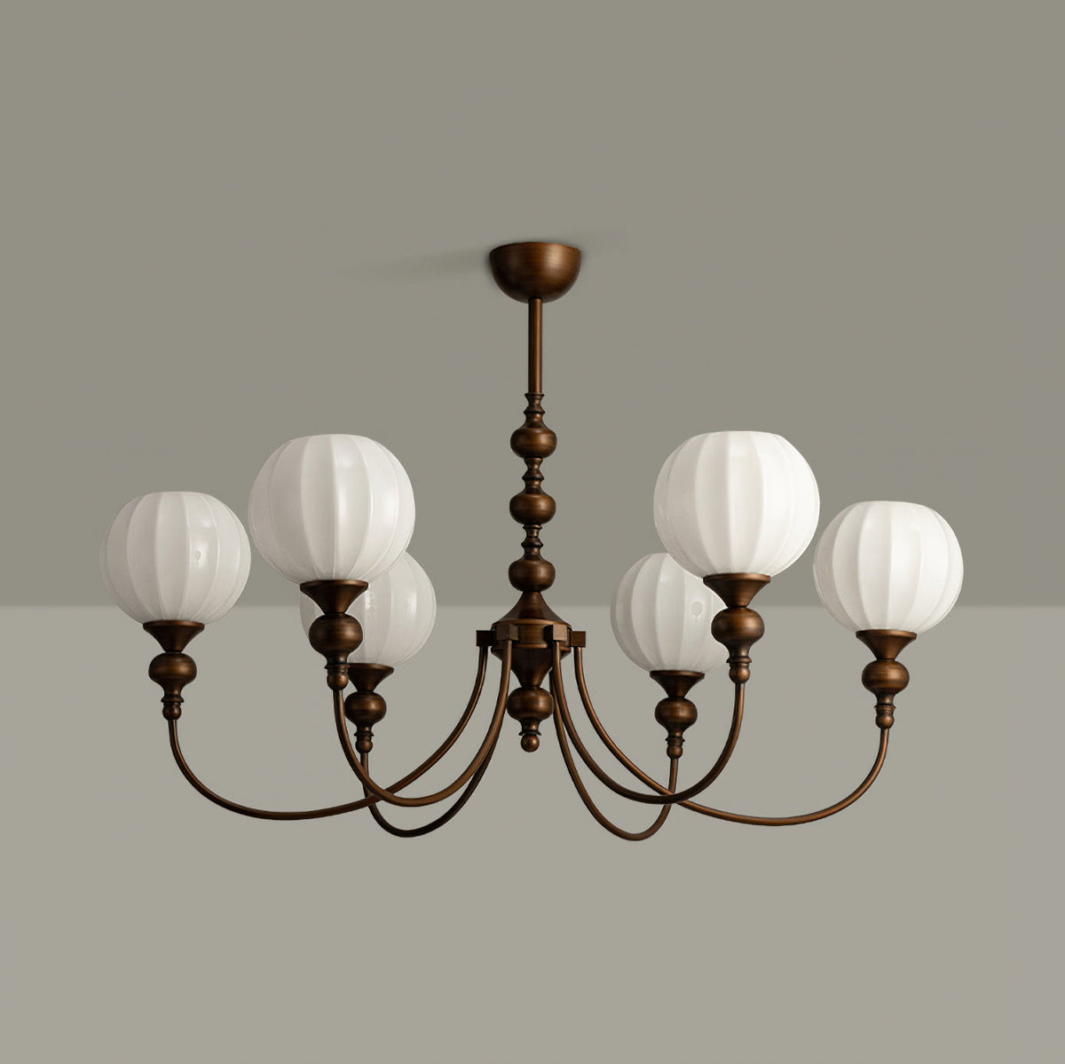 Unlit six-light Clérachic chandelier showing pale ribbed glass globes and the antique bronze arms, against a grey wall and ceiling.