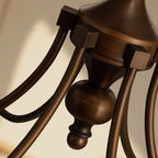 Close view of the turned bronze centre column and the arm joints on this Clérachic chandelier.