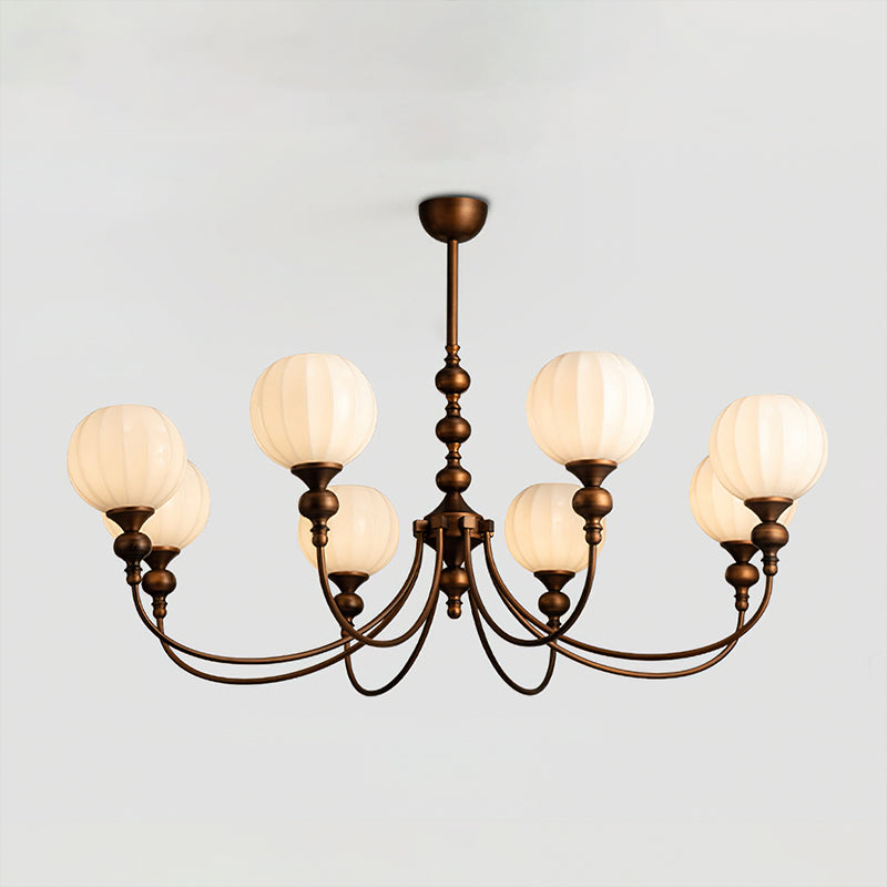 Eight-light Clérachic chandelier switched on, with a wide spread of curved bronze arms and ribbed globes against a pale grey backdrop.