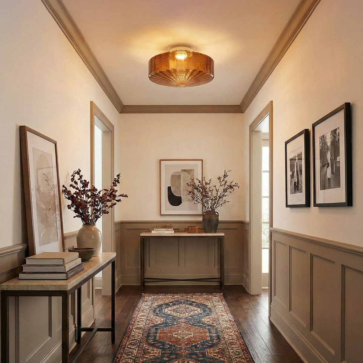 Brown Clérachic ceiling light lit warm in a panelled hallway, with a patterned runner and framed prints on the walls.