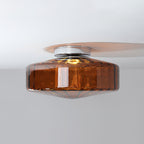Side view of this Clérachic ceiling light in brown ribbed glass, with its chrome plate and the shadow it casts on a white ceiling.