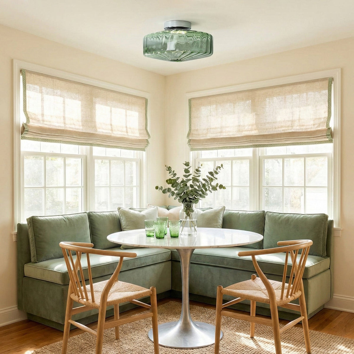 This Clérachic ceiling light in green ribbed glass hangs in a breakfast nook with a green banquette and two wooden chairs.