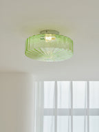 Close view of the green ribbed glass shade and chrome plate of this Clérachic ceiling light, lit from within.