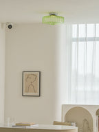 This Clérachic ceiling light in green glass on a white ceiling, with a framed line drawing and a long window below.