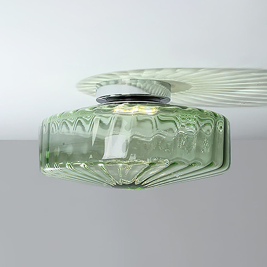 Green ribbed glass Clérachic ceiling light with a chrome plate, throwing a pale fan of light across a white ceiling.