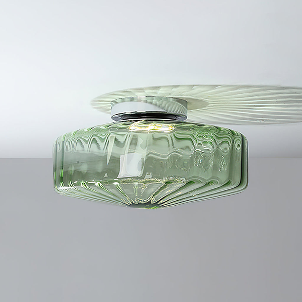 Green ribbed glass Clérachic ceiling light on a white ceiling, with a chrome plate and a pale fan of light above it.