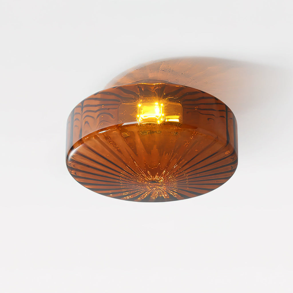 Underside of this brown Clérachic ceiling light on a white ceiling, with fine ribs and a warm bulb glowing in the centre.