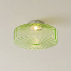 Green Clérachic ceiling light seen from below, with its ribbed underside radiating and a bulb showing through the glass.
