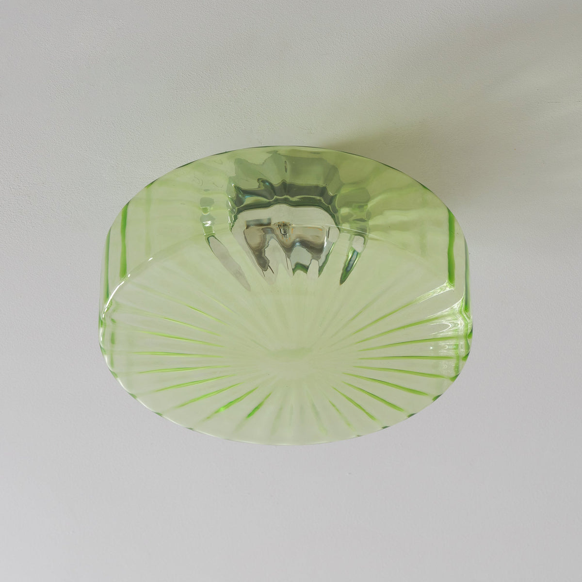 Close view of the pale green ribbed glass and the chrome fitting reflected inside this Clérachic ceiling light.