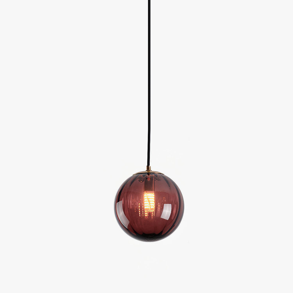Small wine red Clérachic glass globe pendant on a white backdrop, hung on a black cord.
