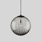 Smoke grey Clérachic glass pendant with a black cap, ribs running down the globe and a bulb inside.