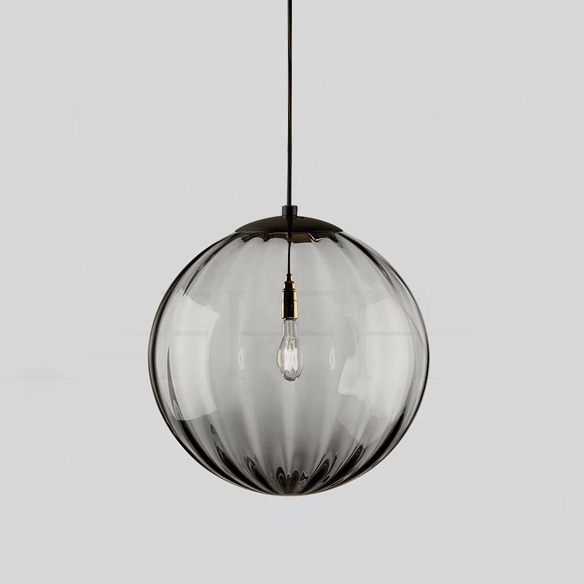 Smoke grey Clérachic glass pendant with a black cap, ribs running down the globe and a bulb inside.