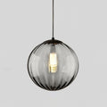 Smaller smoke grey Clérachic glass pendant with a black cap, a bright bulb glowing at its centre.
