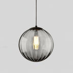Smaller smoke grey Clérachic glass pendant with a black cap, a bright bulb glowing at its centre.
