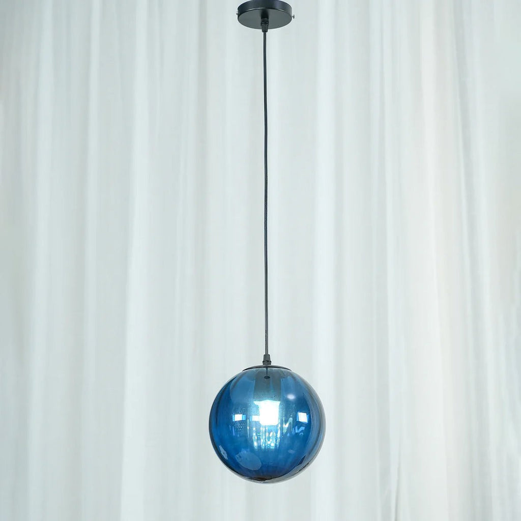 Close view of a blue Clérachic glass pendant and its black canopy, with a sheer curtain behind.