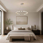 Wide view of a Clérachic pendant ring hung over a bedroom with a cream upholstered bench and an olive branch in a vase.