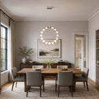 Vertical Clérachic pendant ring over a wooden table with grey chairs, a sideboard and a painting on a pale grey wall.