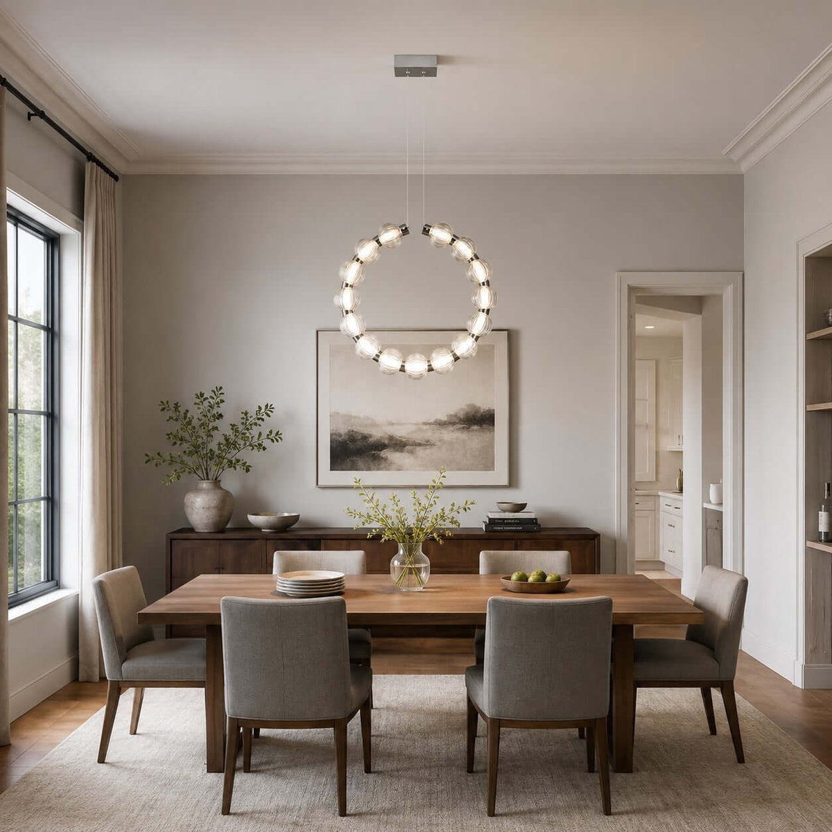 Vertical Clérachic pendant ring over a wooden table with grey chairs, a sideboard and a painting on a pale grey wall.
