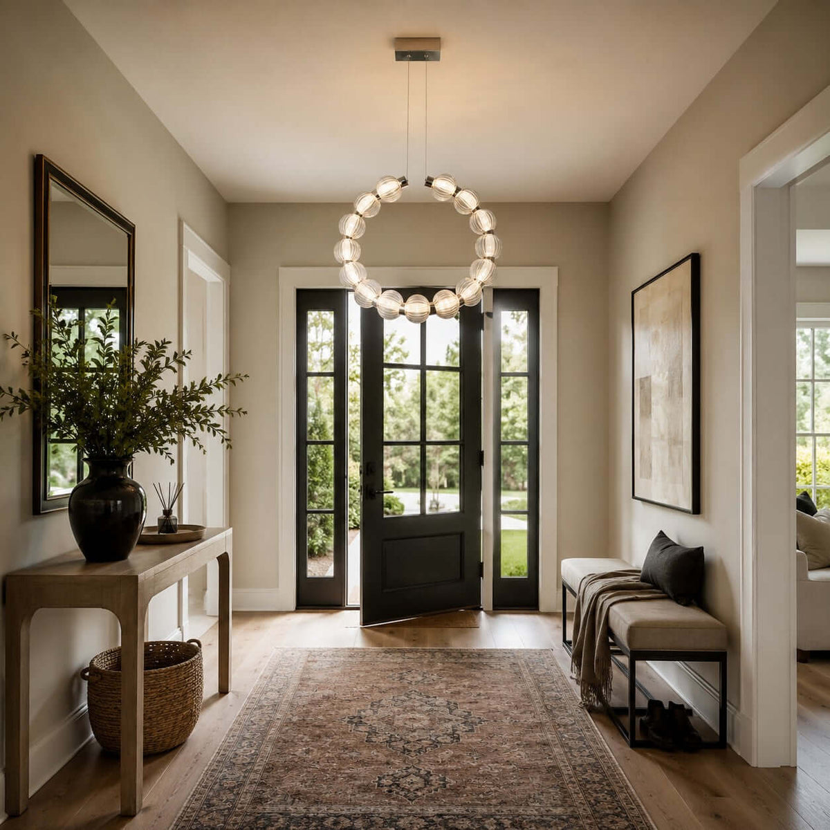 In an entrance hall with a black-framed glass door and a long rug, this Clérachic pendant hangs as a vertical ring of beads.