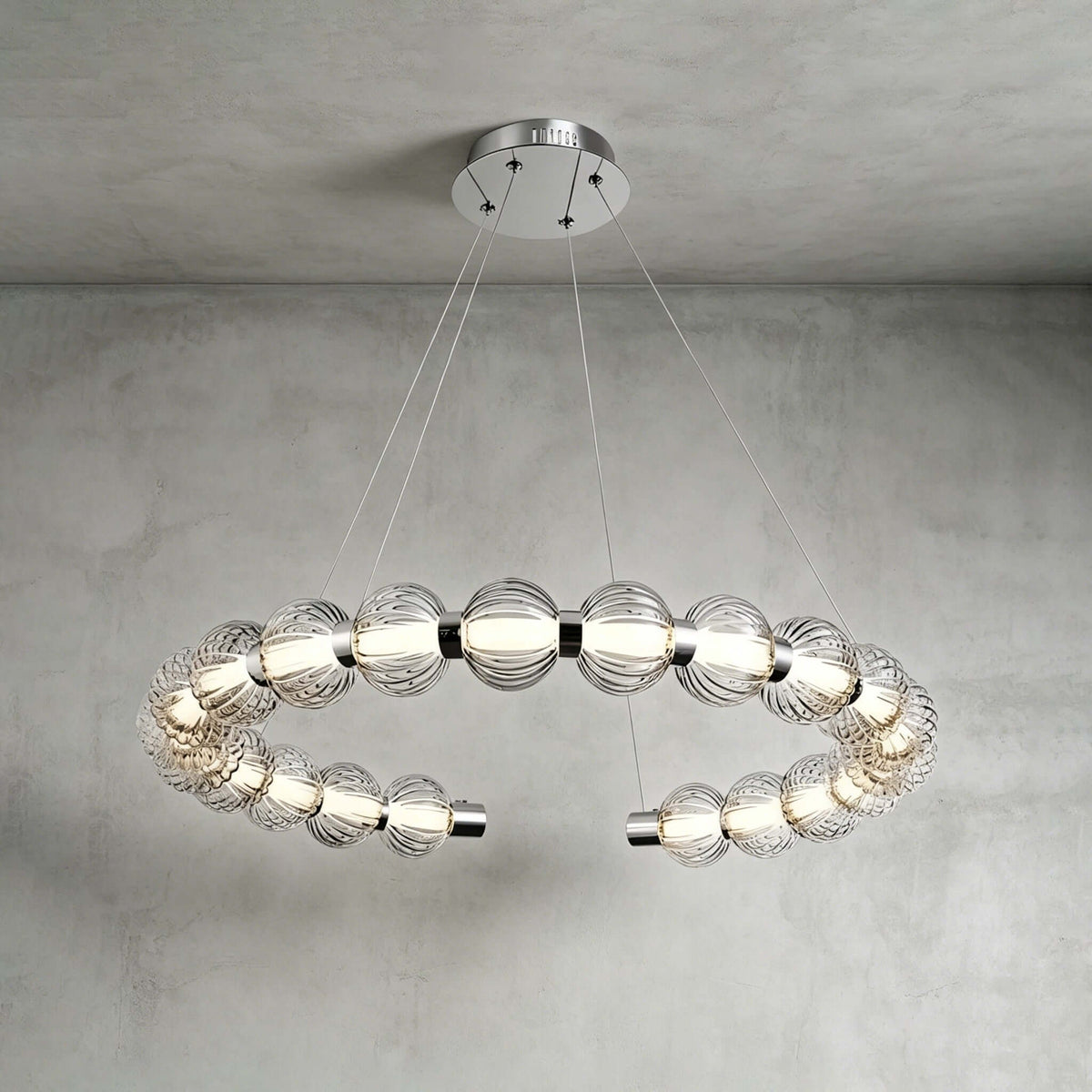 Horizontal open ring of ribbed glass beads with chrome end caps, hung from a round canopy on this Clérachic pendant.