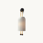 Ribbed white cylindrical shade on gold-finish rods with a black round wall plate and two black ball ends, this Clérachic wall light on white.